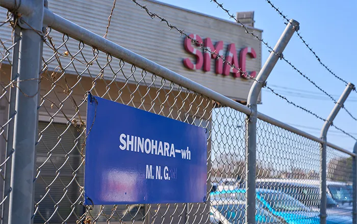 有刺鉄線越しに見える店舗外観ロゴ