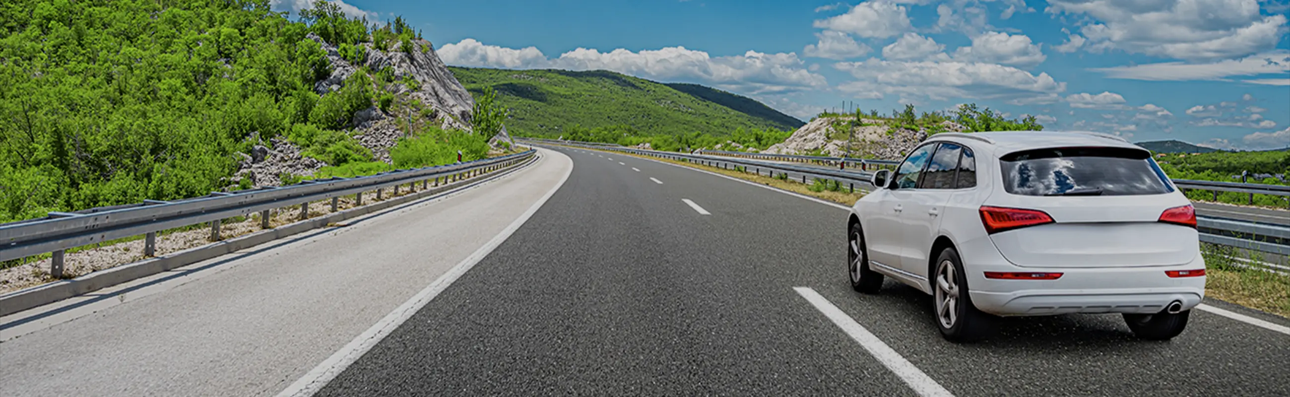 広い道を一台の車が走っている写真